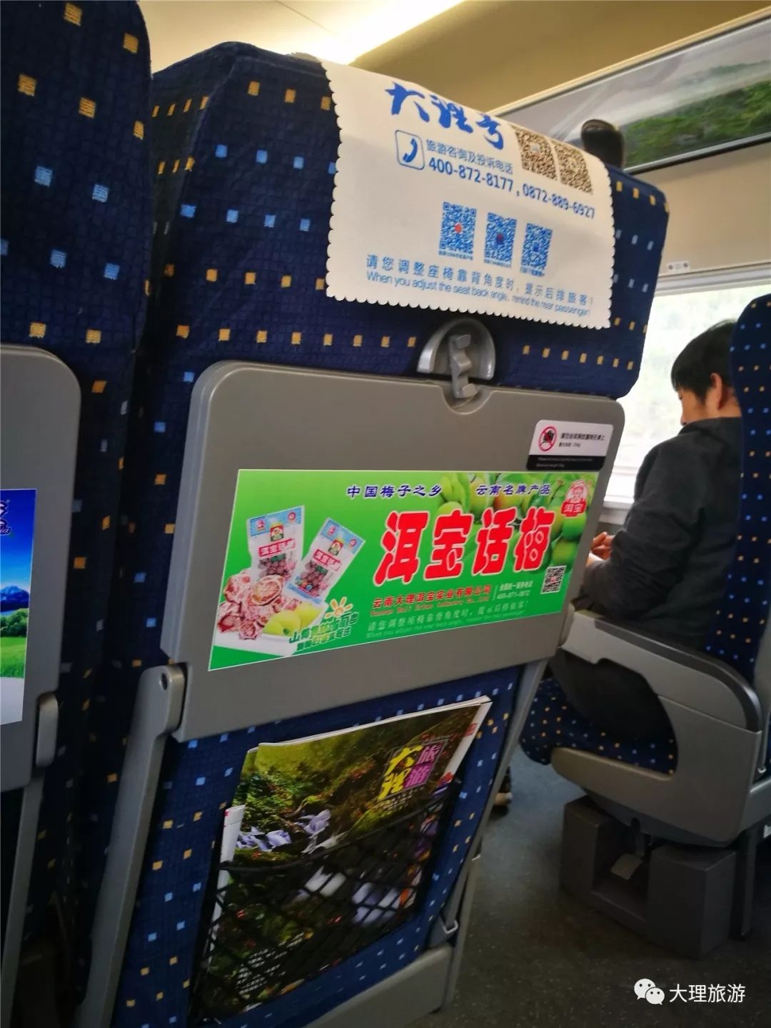 座椅背后头枕片、小桌板上的大理元素及《大理旅游》杂志